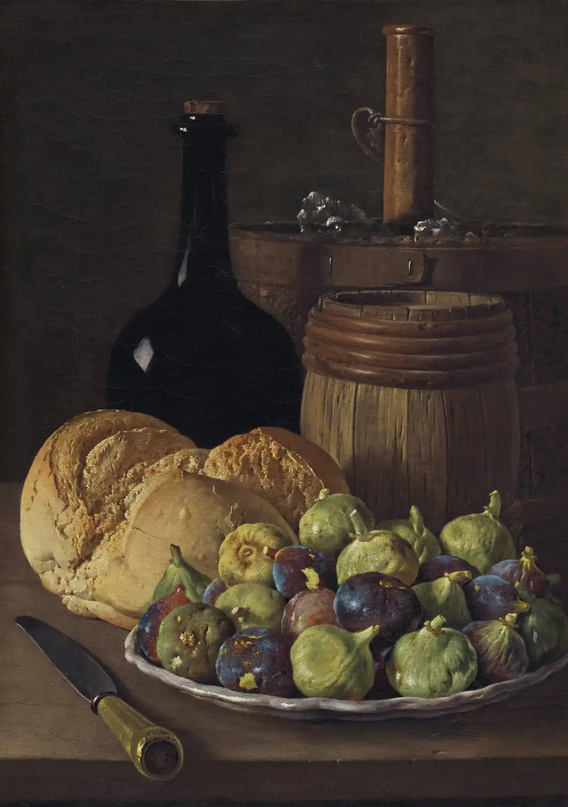 Still life of round crusty bread and a plate of figs with a wooden cask, cork and glass on a bare table.