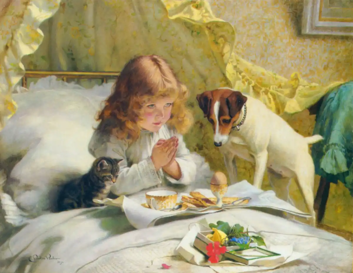A terrier and a kitten wait beside a breakfast tray while a child in bed sits with hands together.